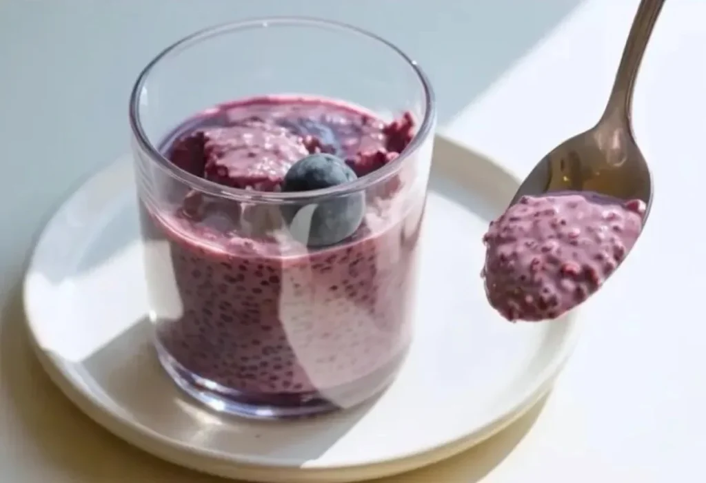 Delicious blueberry chia seed pudding in a glass bowl topped with fresh blueberries.