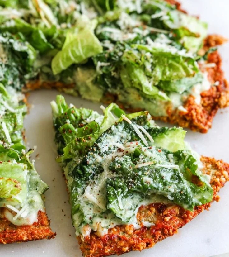 Chicken Caesar Salad Pizza topped with fresh greens and creamy dressing
