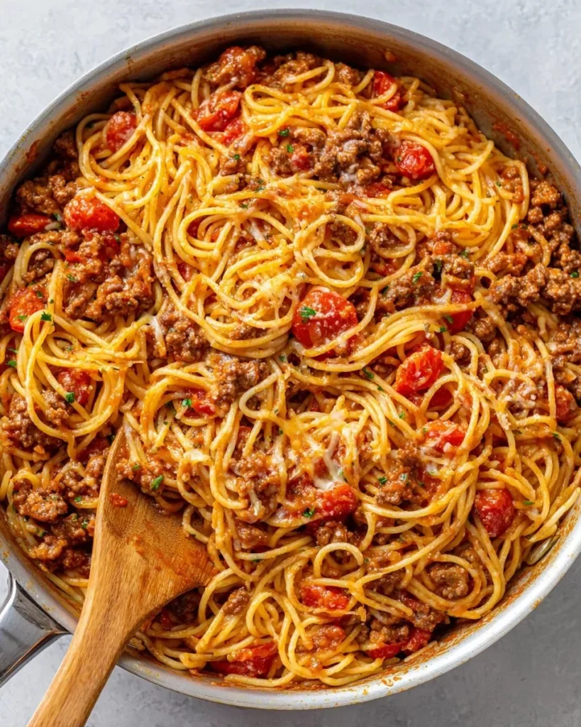 Bowl of delicious Cowboy Spaghetti topped with herbs and cheese