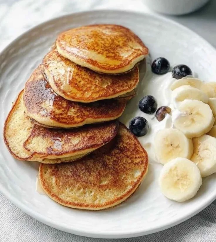 Image of fluffy protein pancakes topped with fruits and syrup