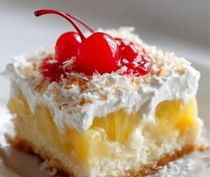Delicious Hawaiian Pineapple Cake topped with fresh pineapple slices and whipped cream.