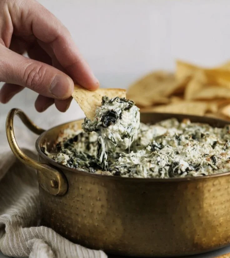 High-Protein Spinach Artichoke Dip served in a bowl with fresh herbs