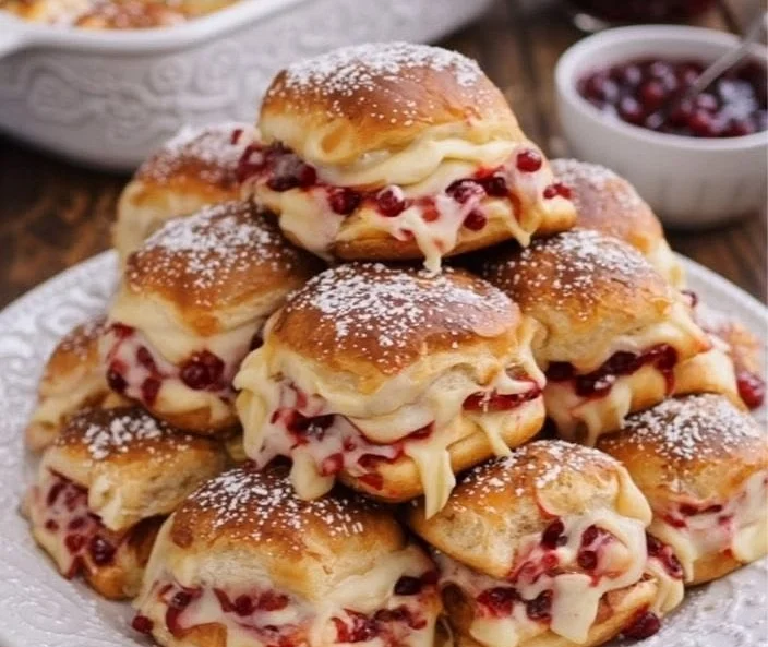 Plate of Monte Cristo Sliders served at a party, featuring cheese and ham.