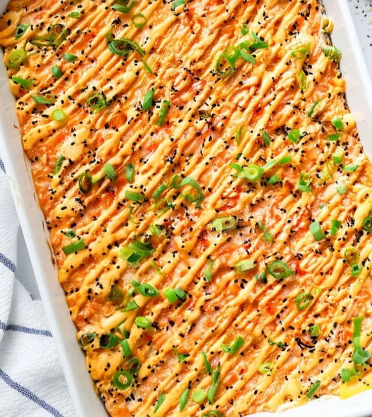Delicious Salmon Sushi Bake served in a dish, topped with fresh ingredients.