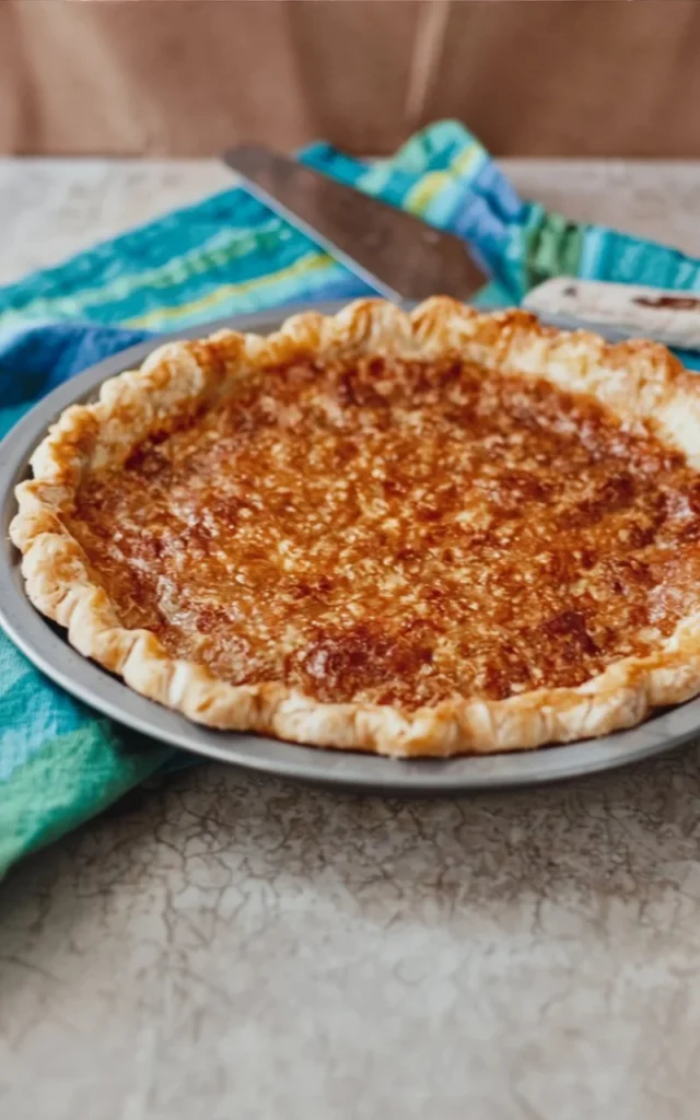 Slice of vinegar pie served with whipped cream on a plate