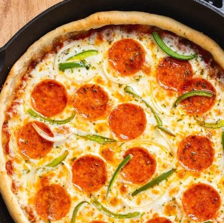 Delicious cast iron skillet pizza with melted cheese and fresh toppings