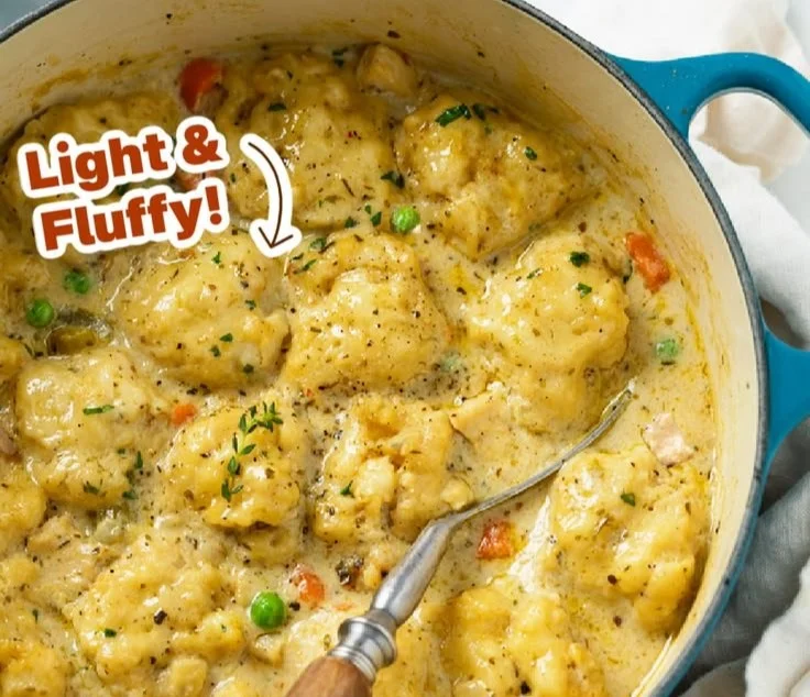 Delicious bowl of Chicken and Dumplings garnished with herbs.