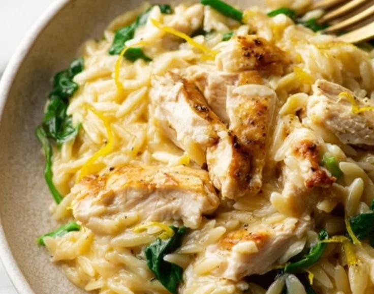 Creamy lemon chicken orzo served in a bowl with fresh herbs