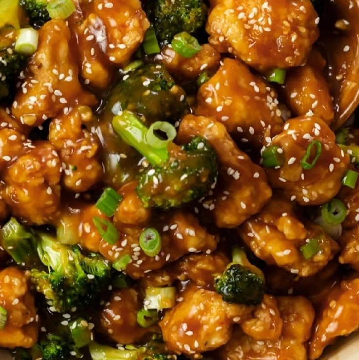 Delicious plate of General Tso's Chicken with vibrant vegetables and sauce.