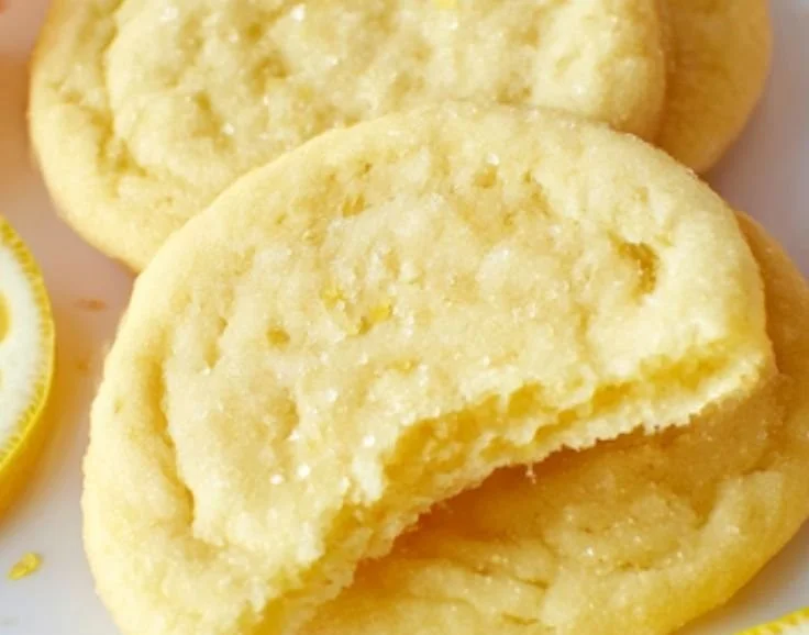 Plate of freshly baked lemon sugar cookies with a decorative lemon slice
