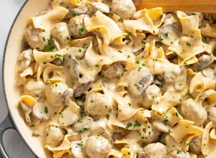 Delicious Meatball Stroganoff served with noodles and garnished with parsley.