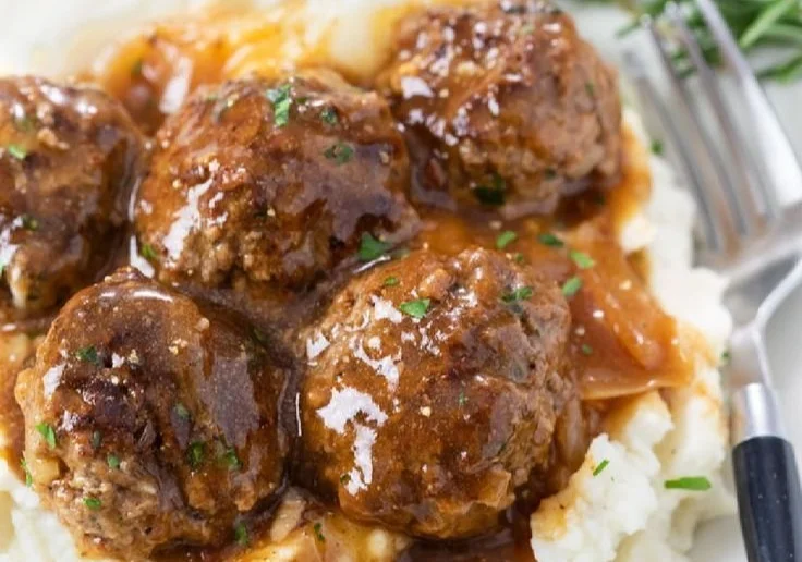 Delicious meatballs served with rich brown gravy on a plate.