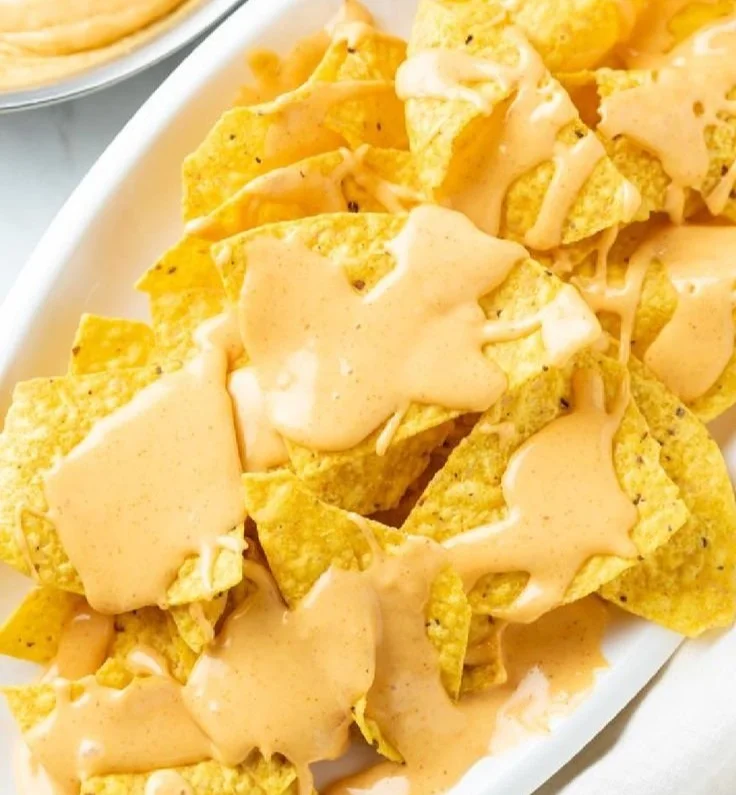 Homemade nacho cheese sauce served in a bowl with tortilla chips