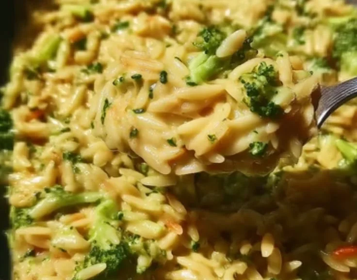 Creamy one pot broccoli cheese orzo topped with melted cheese and fresh broccoli