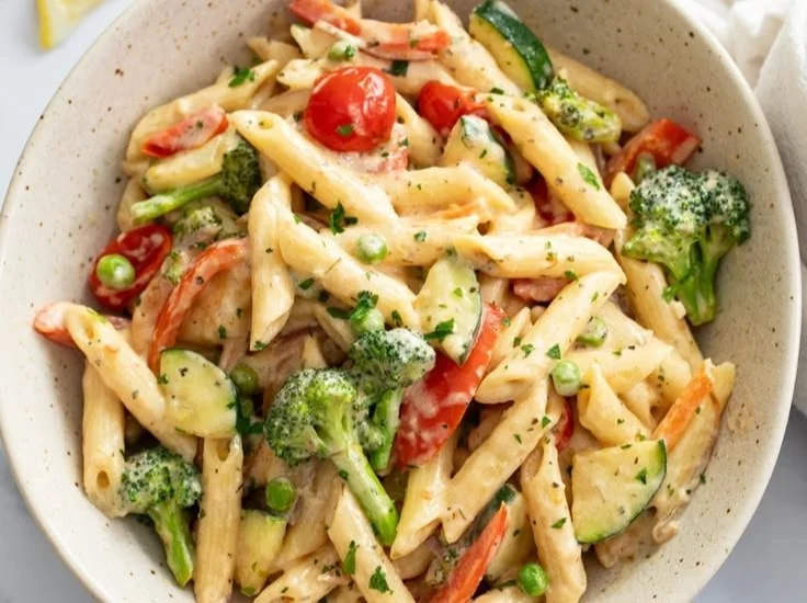 A vibrant spring pasta dish with colorful vegetables and herbs