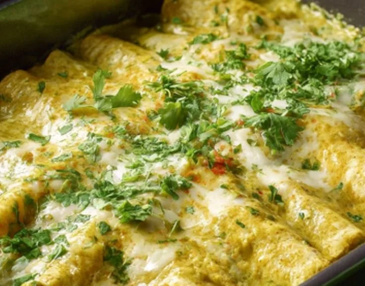 Plate of Swiss Enchiladas with melted cheese and fresh ingredients