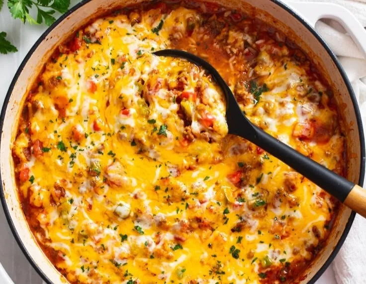 A plate of colorful unstuffed peppers filled with rice, vegetables, and spices.