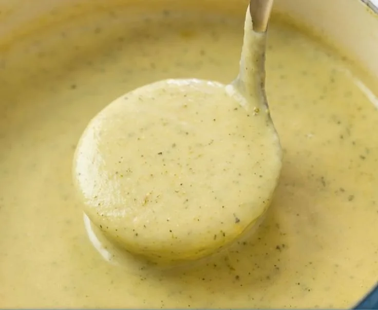 Bowl of creamy zucchini soup garnished with herbs and served with crusty bread