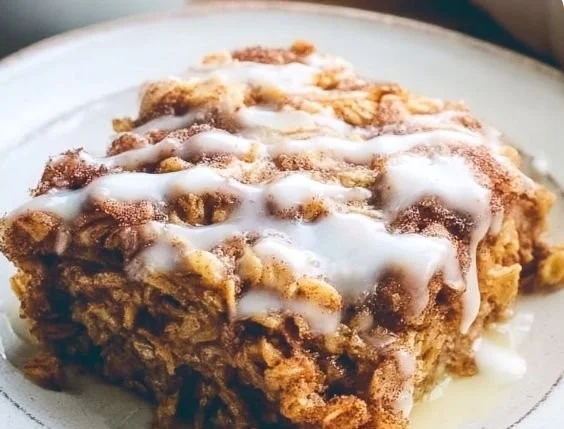 Delicious Cinnamon Roll Baked Oatmeal topped with frosting and cinnamon
