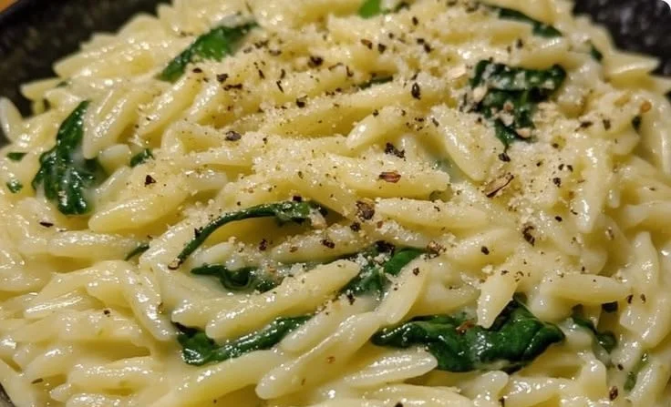 Creamy lemon spinach orzo dish served in a bowl with fresh ingredients