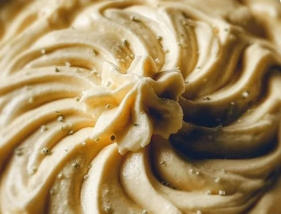 Creamy vegan cashew cheese sauce served in a bowl with fresh herbs.