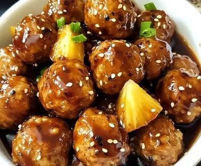 Slow cooker pineapple teriyaki meatballs served with garnishments.