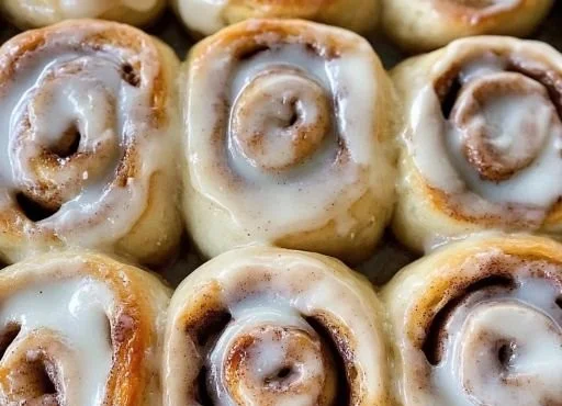 Fluffy gluten-free cinnamon rolls topped with cream cheese frosting.