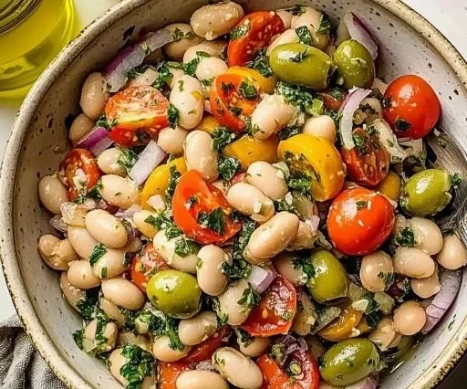 Bowl of Italian white bean salad with fresh vegetables and herbs.