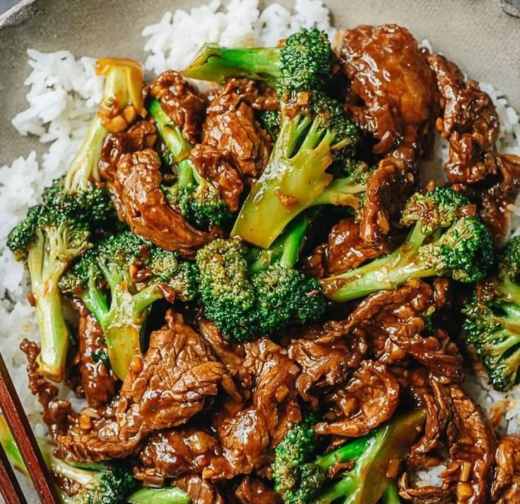 Beef and broccoli stir-fry served in a bowl with steamed rice.