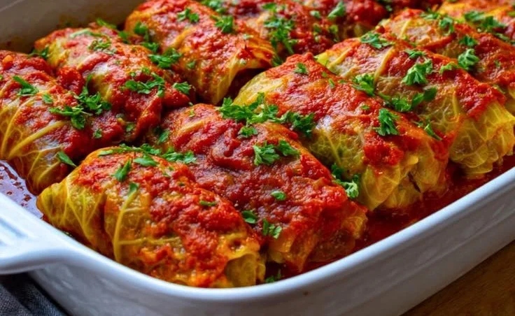 Plate of delicious beef stuffed cabbage rolls topped with sauce
