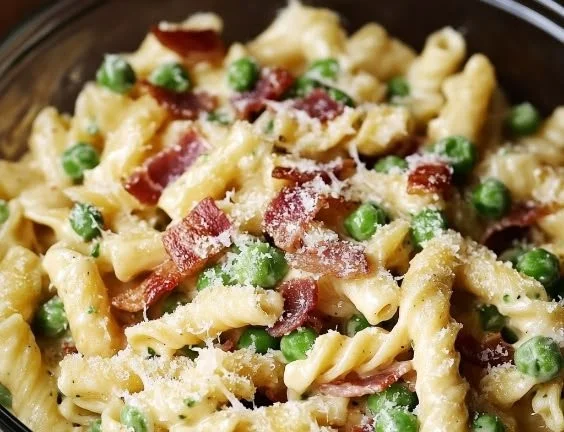 Creamy pea bacon pasta salad with fresh ingredients in a bowl