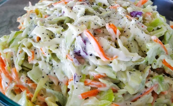 A bowl of vibrant high-protein coleslaw with colorful vegetables and dressing.