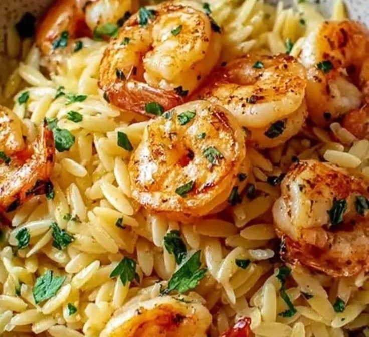Plate of Shrimp Orzo in Lemon Garlic Sauce garnished with herbs
