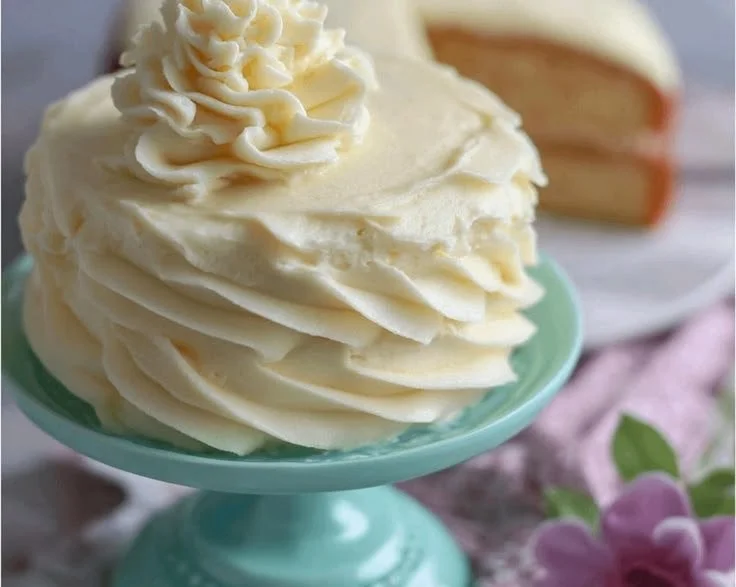 Delicious homemade vanilla buttercream frosting spread on a freshly baked cake.
