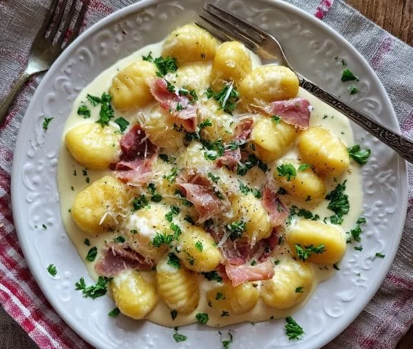Creamy garlic parmesan gnocchi served with herbs on a plate