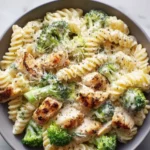 Creamy rotisserie chicken and broccoli pasta dish garnished with herbs