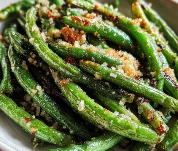 Dish of Garlic Parmesan Roasted Green Beans garnished with grated cheese