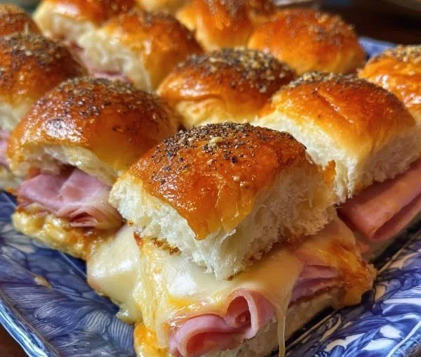 Ham and cheese sliders on Hawaiian rolls topped with tasty herbs.
