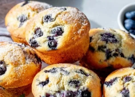 Delicious jumbo blueberry muffins with fresh blueberries displayed on a plate.