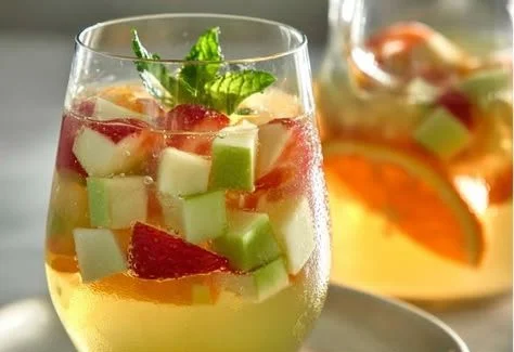 Glass of Green Apple Sangria with fruits, perfect for summer gatherings